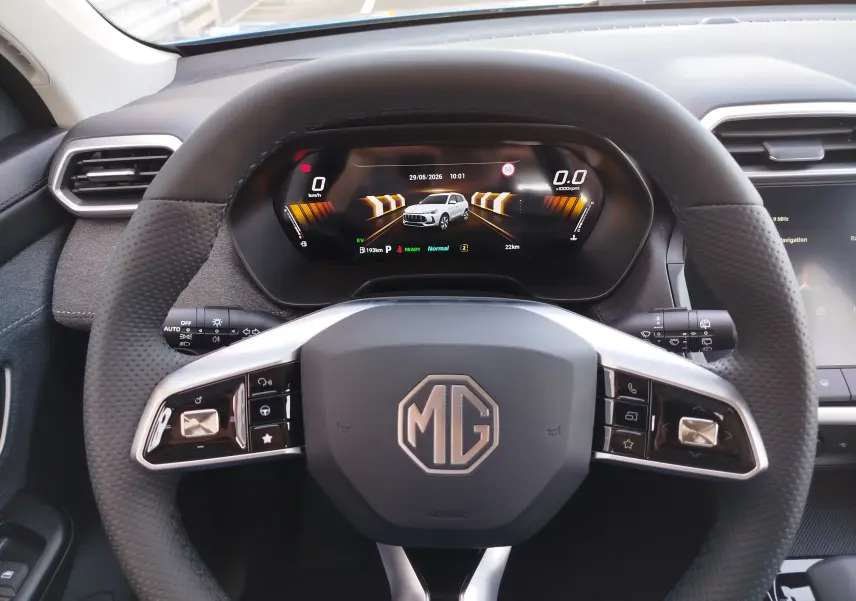 Vue intérieure centrée sur le volant noir perforé MG ZS 2026 avec tableau de bord numérique et écran tactile partiel.