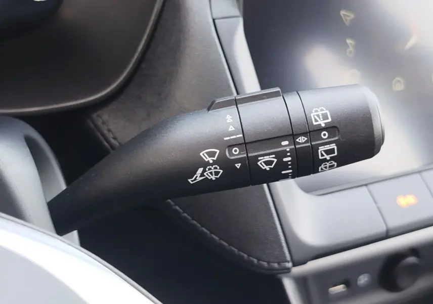 Gros plan sur la commande des essuie-glaces du MG ZS 1.5 L Hybrid+ 2026, intérieur noir avec écran tactile visible.