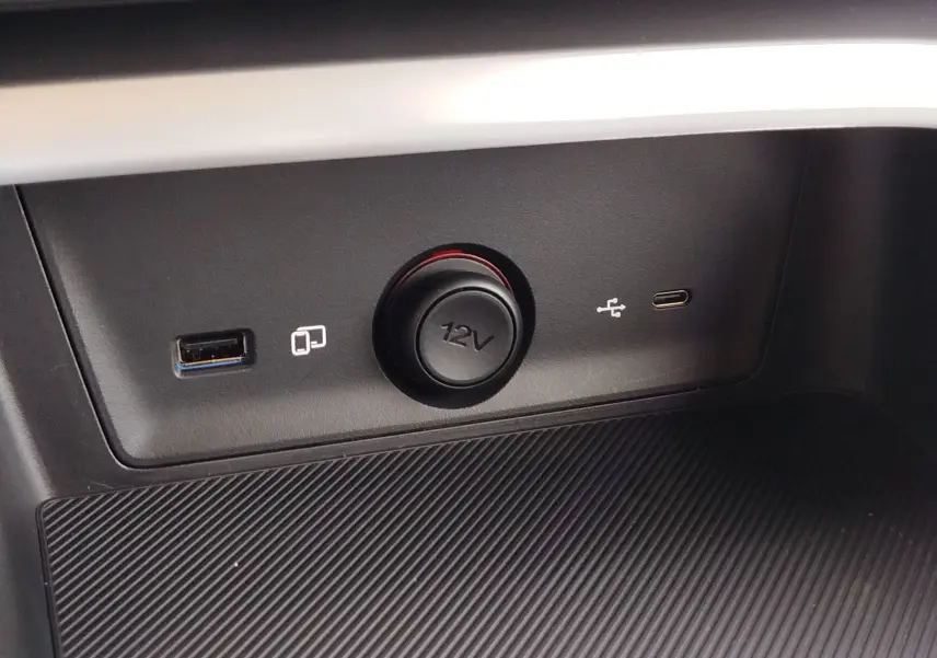 Gros plan sur la prise 12V et ports USB-A et USB-C intégrés dans la console centrale noire du MG ZS Cosmo Blue.