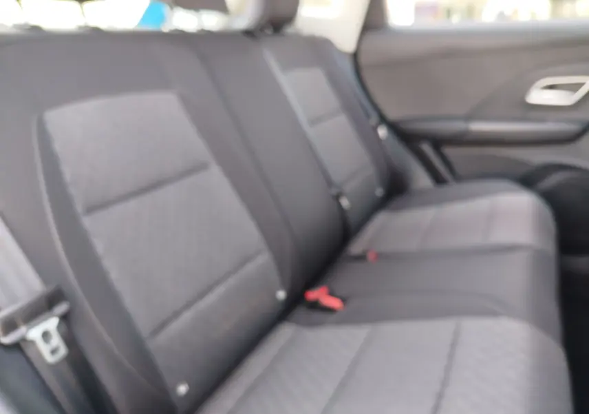 Vue intérieure des sièges arrière en tissu noir du MG ZS 1.5 L Hybrid+ 2026, avec ceinture de sécurité visible.