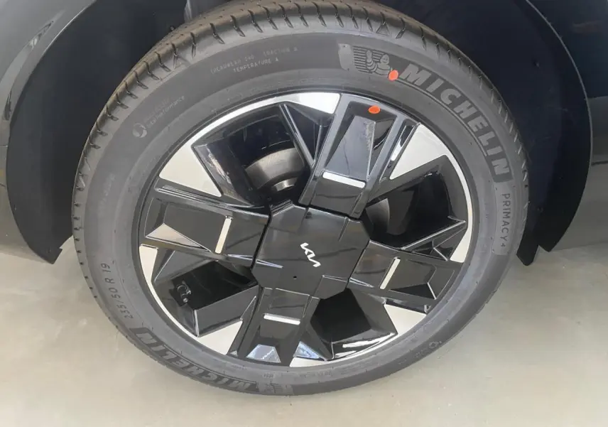 Gros plan sur la jante noire et argentée du Kia Sportage hybride 2026 avec logo Kia au centre.