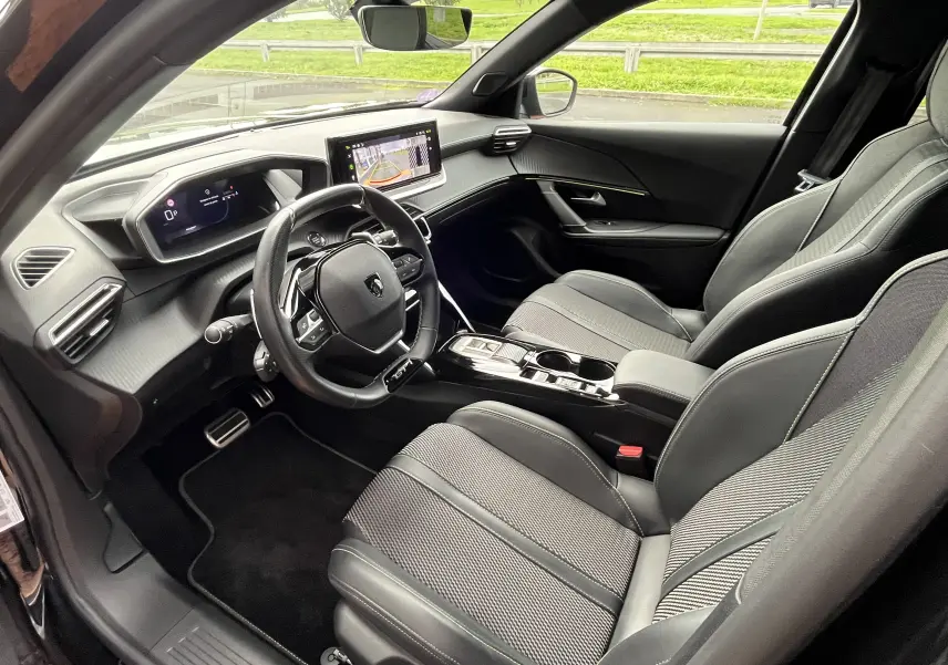 Intérieur noir du Peugeot 2008 2024 vu côté conducteur, avec tableau de bord numérique et écran central tactile.
