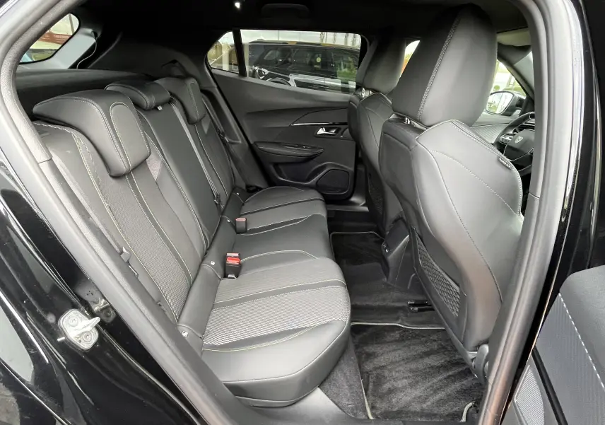 Vue intérieure arrière côté gauche du Peugeot 2008 noir 2024, sièges arrière en cuir et tissu avec surpiqûres contrastantes.