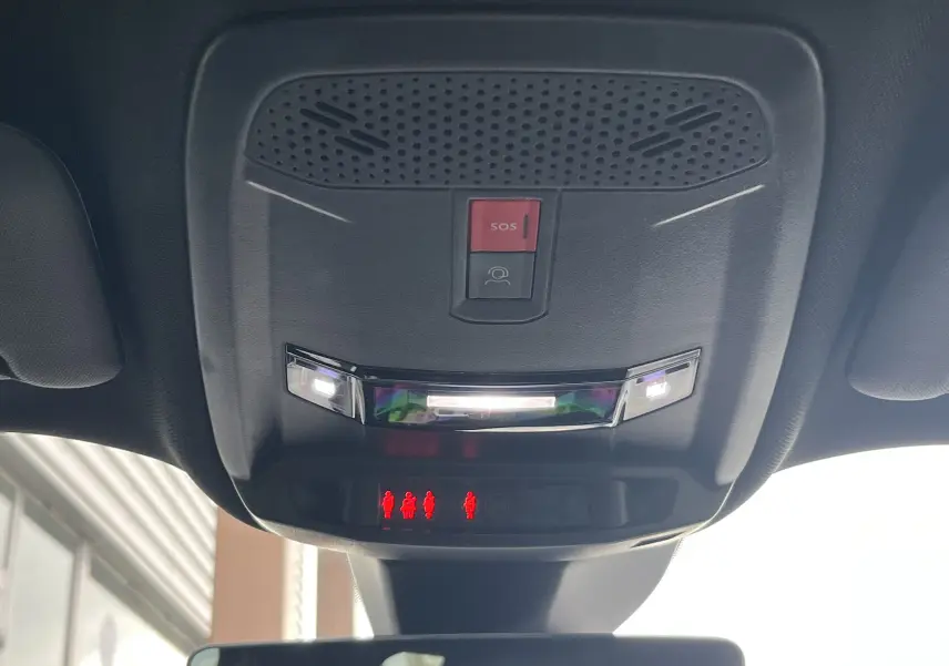 Vue en contre-plongée du plafonnier noir avec bouton SOS et éclairage intérieur du Peugeot 2008 GT 2024.