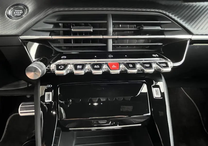 Vue rapprochée de la console centrale noire du Peugeot 2008 GT 2024, avec boutons de commande et bouton start/stop visible.
