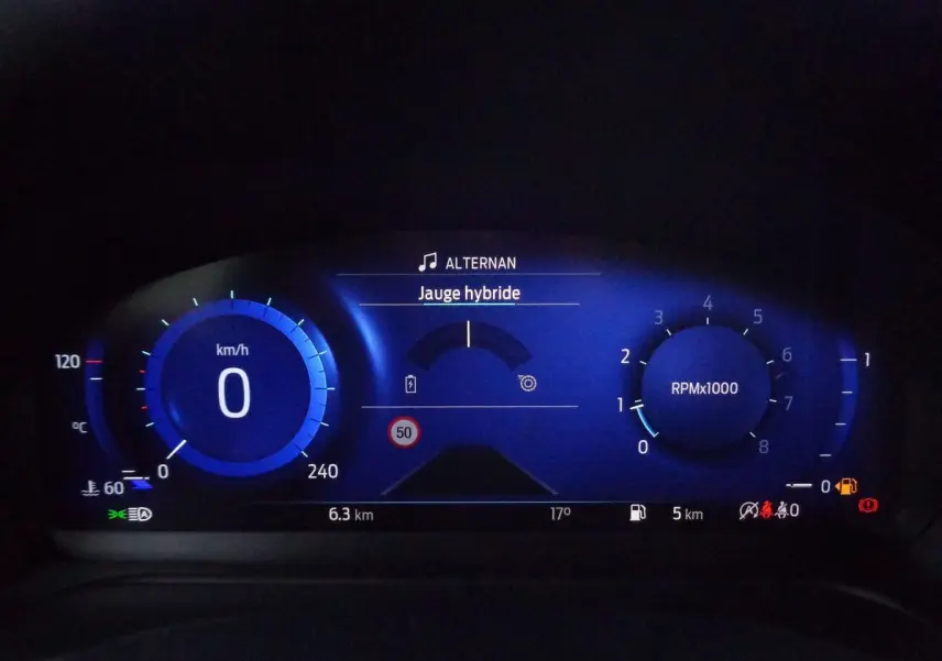 Tableau de bord numérique bleu du Ford Puma 1.0 EcoBoost MHEV 155ch, affichant vitesse, régime et jauge hybride.
