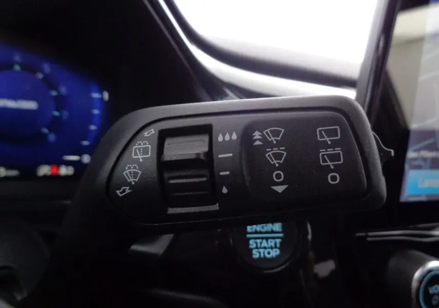 Gros plan sur la commande des essuie-glaces du Ford Puma noir agate métal, avec tableau de bord et bouton start visible.