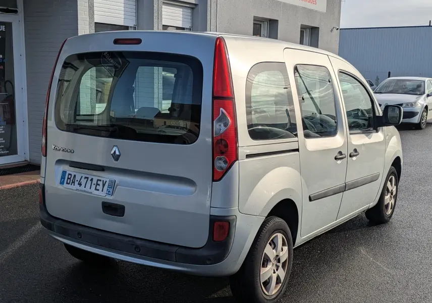 Renault Kangoo bleu ciel vu de l'arrière côté droit, avec portes latérales coulissantes et vitres teintées.