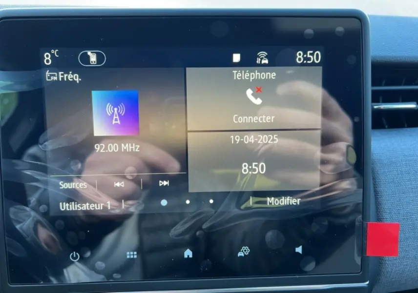 Écran tactile central de la Renault Clio DCI 100 Evolution Camera 2025 affichant radio et téléphone, intérieur gris schiste.
