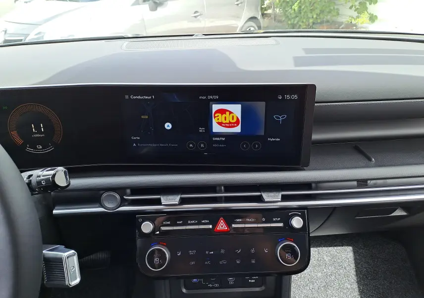 Tableau de bord du Hyundai Tucson 2025 en vue frontale, écran tactile affichant radio DAB et commandes climatisation digitales.