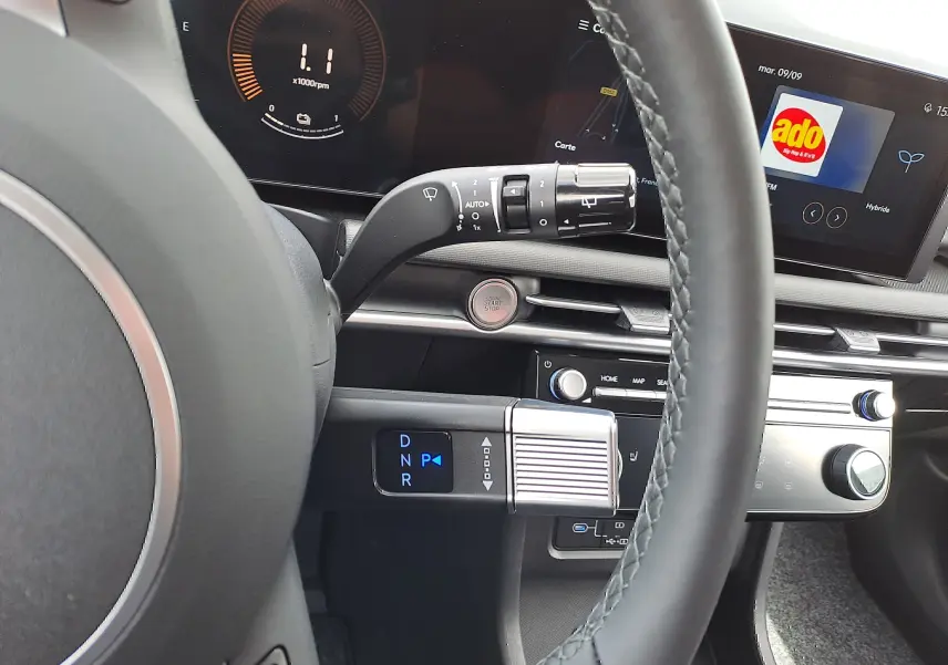 Intérieur du Hyundai Tucson 2025, vue sur le volant et la console centrale avec écran tactile et levier de vitesses digital.