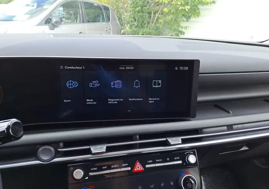 Tableau de bord du Hyundai Tucson 2025 en gris Ecotronic, vue intérieure centrée sur l'écran tactile et commandes climatiques.