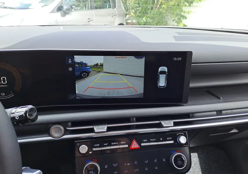 Vue intérieure du tableau de bord du Hyundai Tucson 2025 avec écran de caméra de recul et commandes climatisation.