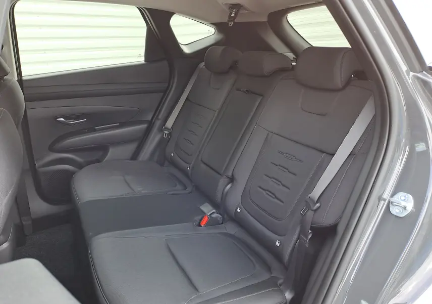 Vue intérieure côté droit des sièges arrière noirs en tissu du Hyundai Tucson 2025 Ecotronic Grey, version hybride.