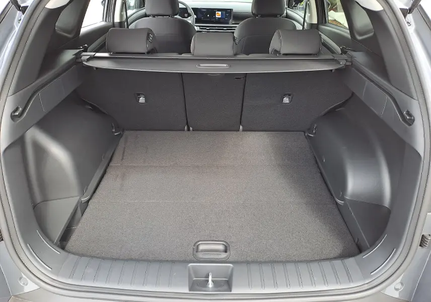 Coffre ouvert d'un Hyundai Tucson 2025 gris Ecotronic, vue arrière montrant l'espace de chargement et la banquette arrière noire.