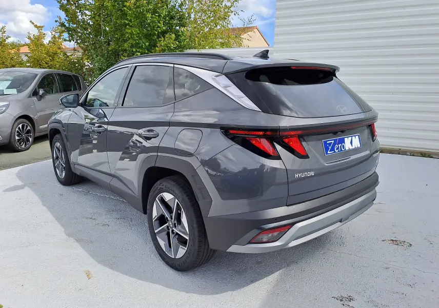 Vue 3/4 arrière droite du Hyundai Tucson 2025 hybride en gris Ecotronic avec feux arrière LED et jantes alliage.