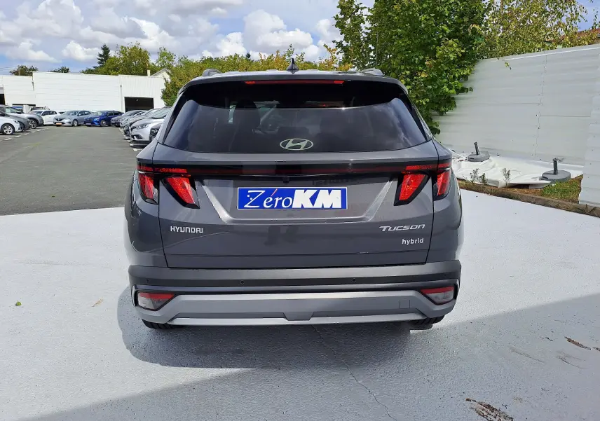Vue arrière d'un Hyundai Tucson 2025 hybride en gris Ecotronic, avec feux arrière LED et logo Hyundai visible.