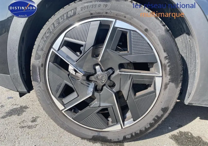 Gros plan sur la jante alu noire au design géométrique du Peugeot 408 Hybrid 145 GT e-dcs6 noir, roue avant droite.