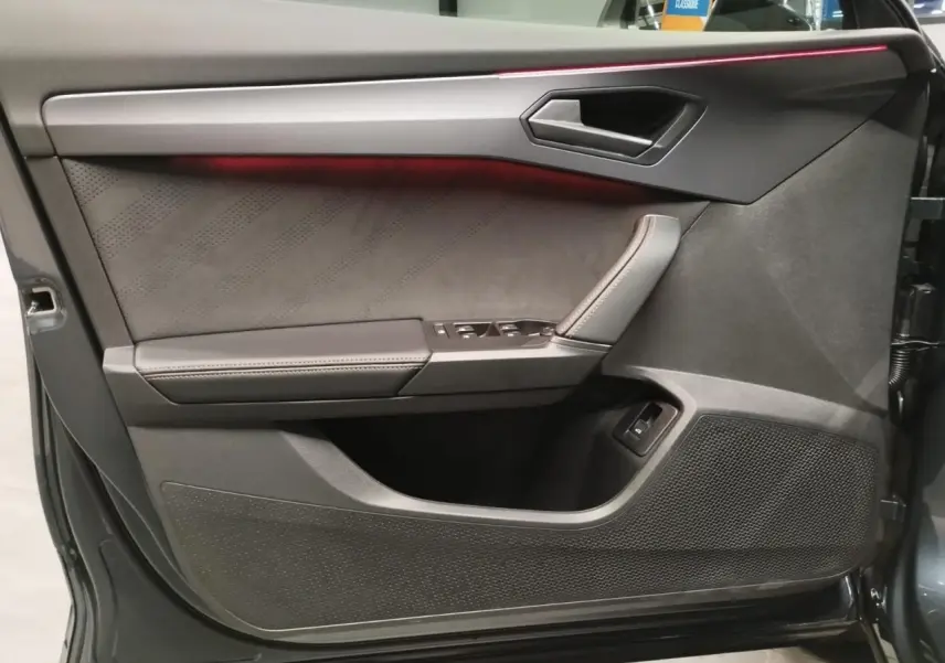 Vue intérieure côté gauche de la porte avant d'une CUPRA Formentor 2.0 TDI Magnetic Tech avec éclairage d'ambiance rouge.
