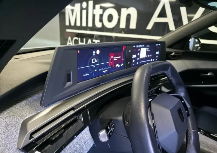 Vue intérieure du tableau de bord du Peugeot 3008 blanc 2025, avec volant compact cuir et double écran HD panoramique.