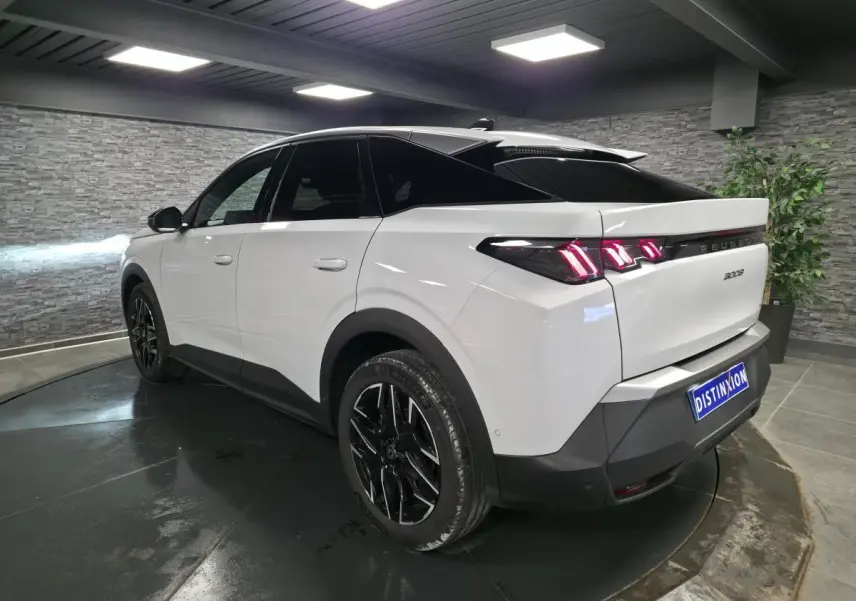 Peugeot 3008 blanc vue 3/4 arrière droit, jantes alliage noires et feux arrière LED 3 griffes visibles.