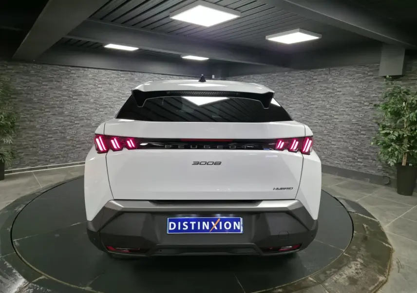 Vue arrière d’un Peugeot 3008 blanc hybride 2025 avec feux arrière LED 3 griffes et bandeau noir laqué.