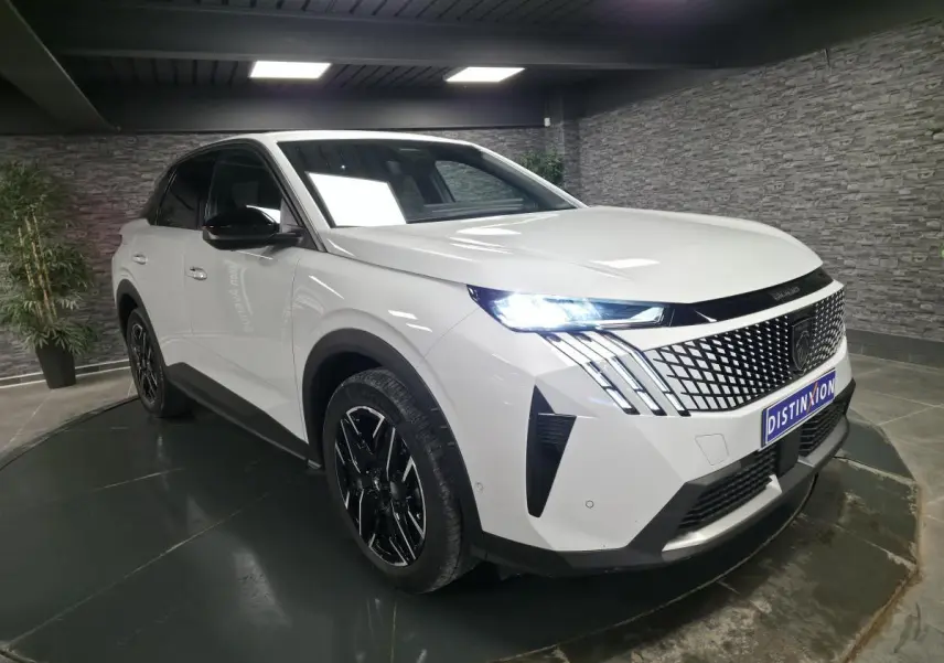 Peugeot 3008 blanc en 3/4 avant droit, avec calandre noire à motif géométrique et feux LED allumés.