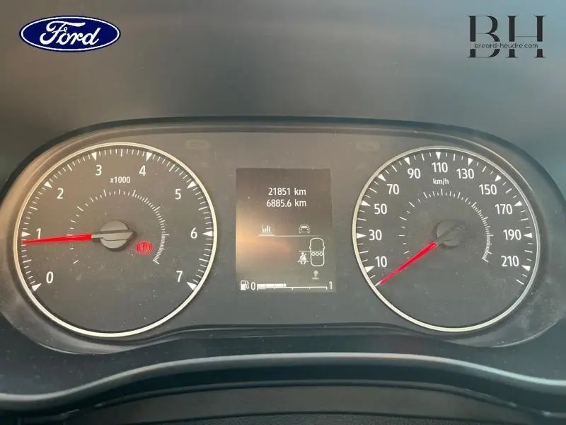 Vue rapprochée du tableau de bord de la Dacia Sandero blanc, affichant compte-tours, vitesse et écran central digital.