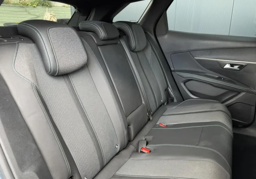 Vue latérale droite de la banquette arrière en tissu et cuir noir avec surpiqûres contrastées du Peugeot 3008 2024.