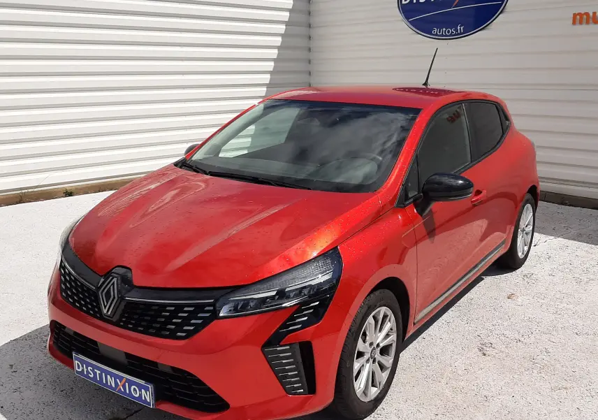 Renault Clio V rouge flamme vue 3/4 avant droit, avec calandre noire et phares LED distinctifs.