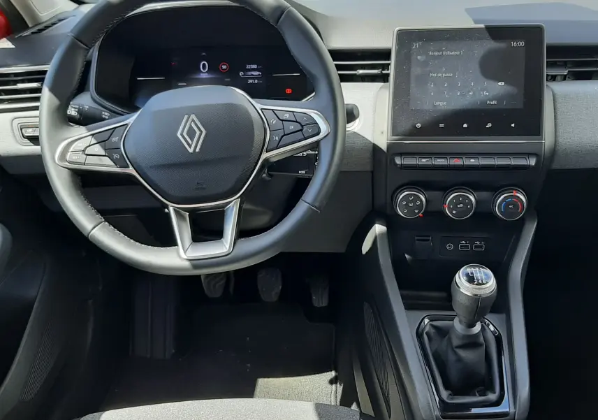 Vue intérieure frontale du poste de conduite de la Renault Clio V DCI 100ch, volant multifonction et écran tactile central.