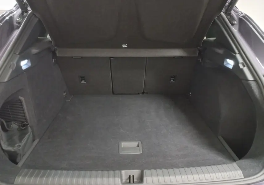 Vue intérieure du coffre ouvert du CUPRA TERRAMAR violet intersidéral, montrant un espace de rangement propre et spacieux.
