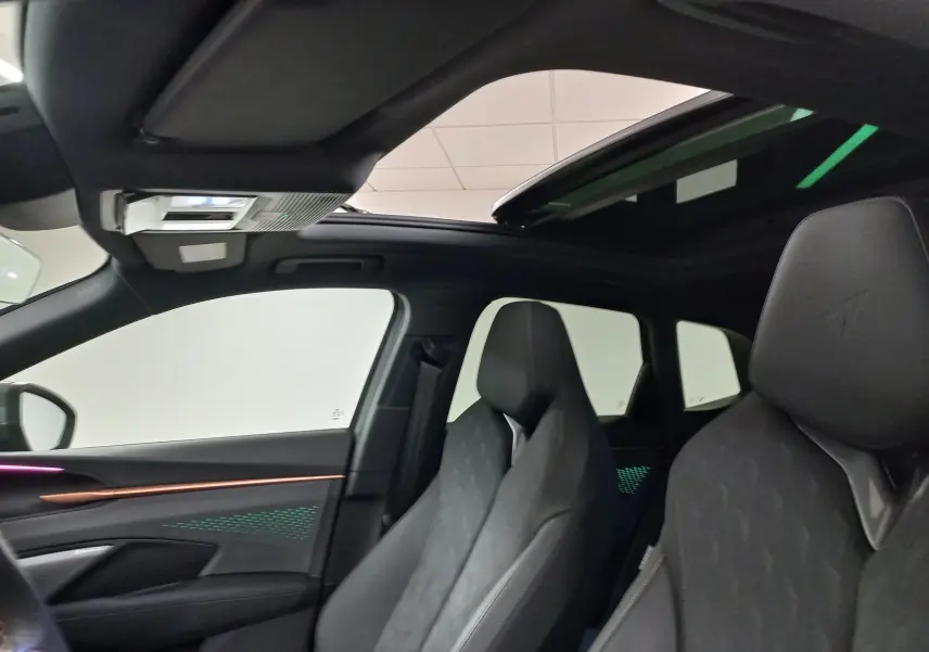 Vue intérieure avant du CUPRA TERRAMAR 2025 avec toit ouvrant panoramique et sièges noirs au logo Cupra embossé.