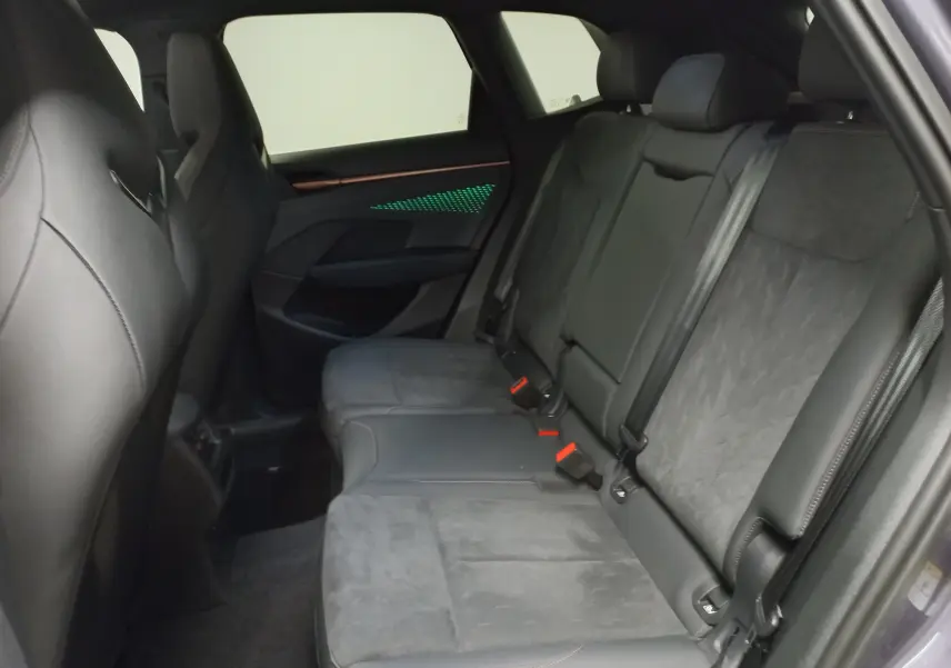 Vue latérale intérieure des sièges arrière en cuir noir du CUPRA TERRAMAR 2025 avec éclairage d'ambiance vert sur la porte.