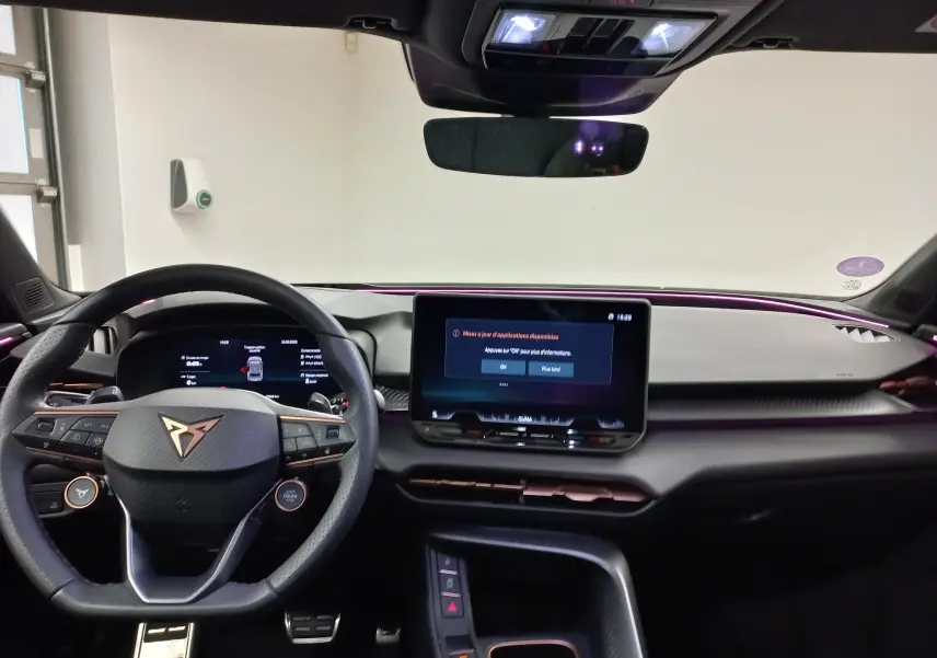 Vue intérieure avant du tableau de bord du CUPRA TERRAMAR violet intersidéral avec écran tactile et volant multifonction.