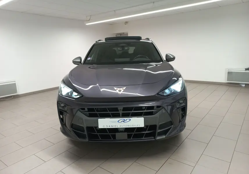 Vue avant d'une CUPRA TERRAMAR violet intersidéral avec phares allumés et toit ouvrant en intérieur showroom.