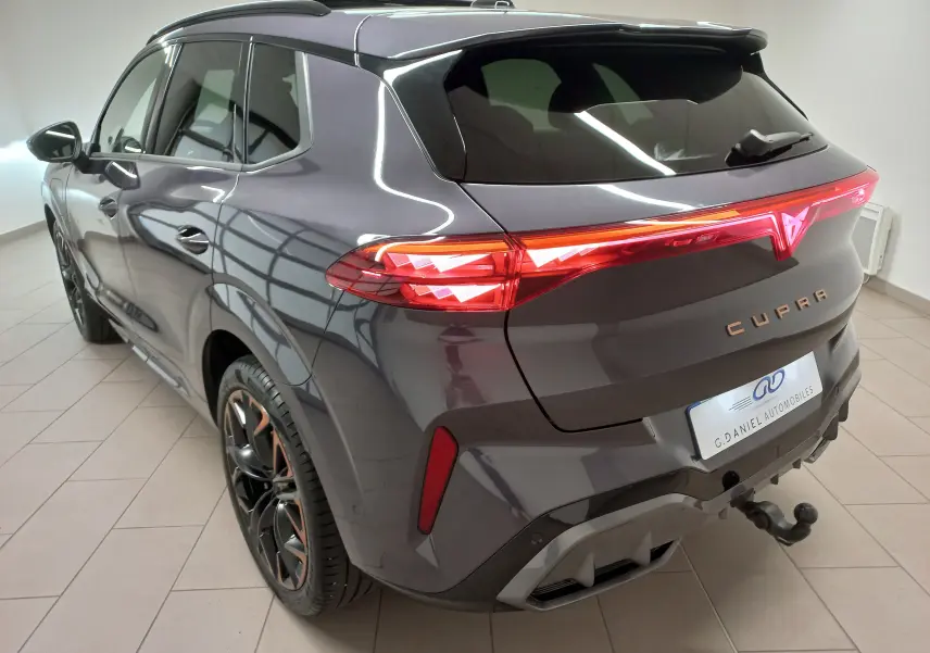 Vue 3/4 arrière droite d'une CUPRA TERRAMAR violet intersidéral avec jantes cuivrées et crochet d'attelage escamotable.