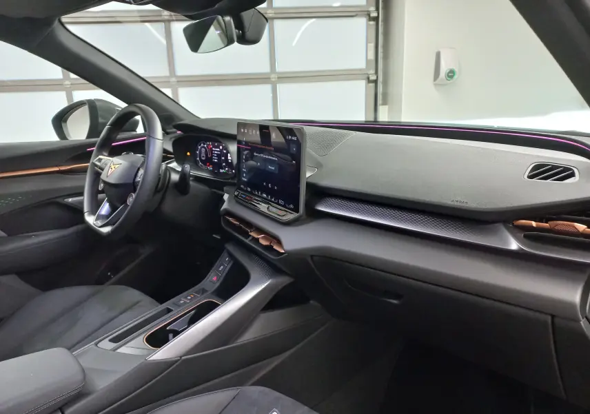 Vue intérieure côté conducteur du CUPRA TERRAMAR 2025 avec tableau de bord numérique et éclairage d'ambiance violet.