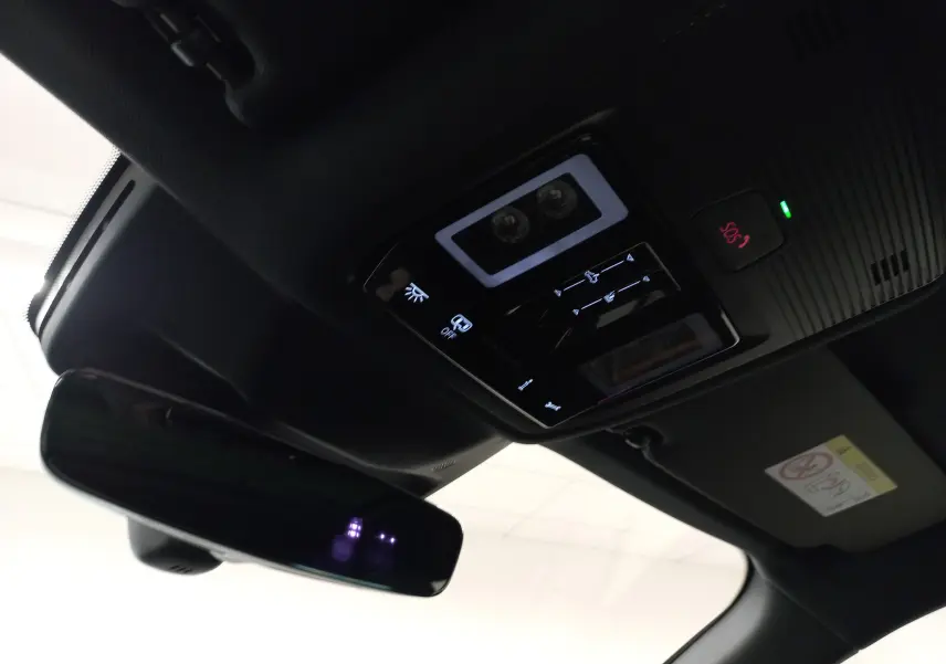 Vue intérieure en contre-plongée du plafonnier noir avec commandes lumineuses et rétroviseur du CUPRA Terramar violet intersidéral.