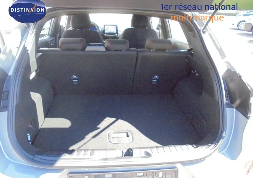 Coffre ouvert d'une Ford Puma gris Solar Metal, vue arrière montrant l'espace de chargement et les sièges arrière relevés.