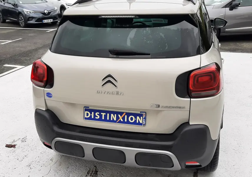 Vue arrière d'une Citroën C3 Aircross sable métal avec feux rouges carrés et pare-chocs noir mat.