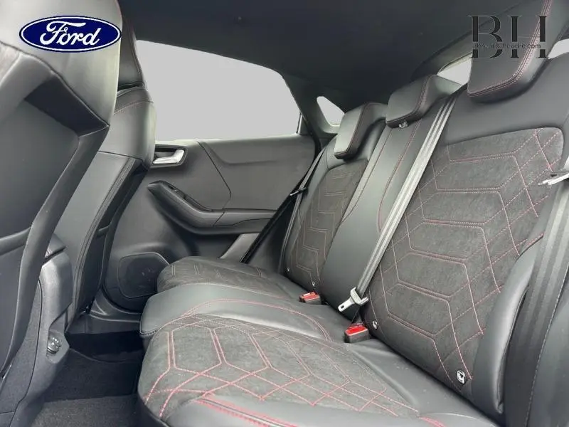 Vue latérale intérieure des sièges arrière noirs avec surpiqûres rouges du Ford Puma 2025 gris Solar Métallisée.
