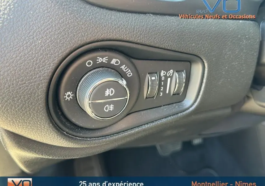 Gros plan sur le bouton de commande des phares du Jeep Renegade noir 2024, montrant les réglages d'éclairage et antibrouillard.