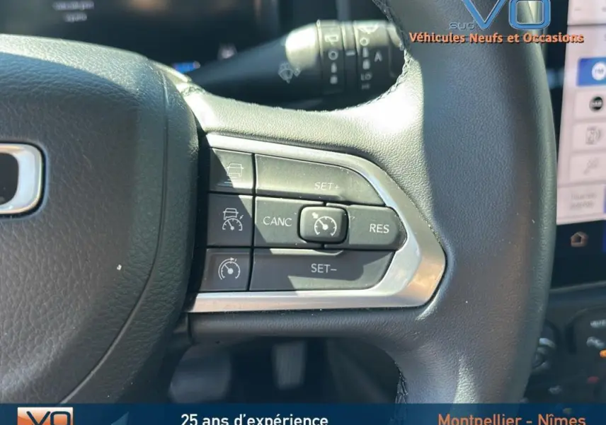 Gros plan sur les commandes de régulateur de vitesse au volant noir du Jeep Renegade 2024 e-Hybrid Summit.