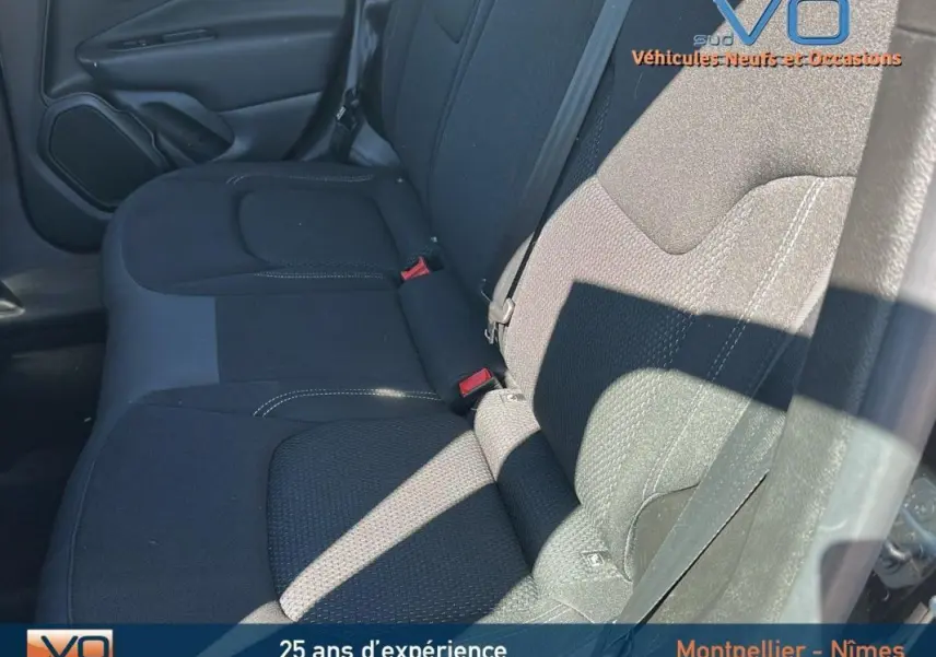 Vue latérale intérieure montrant la banquette arrière noire du Jeep Renegade 2024 avec ceintures et appuie-têtes visibles.