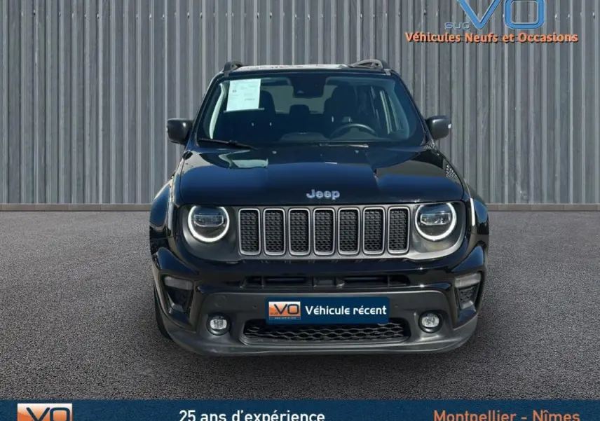 Vue frontale d'un Jeep Renegade noir 2024 avec phares LED ronds et barres de toit visibles sur fond industriel.