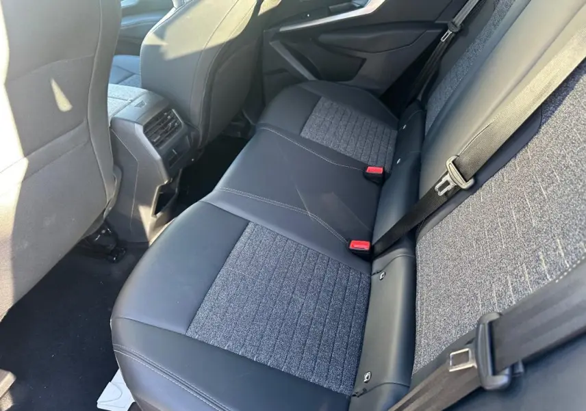 Vue intérieure arrière droite des sièges bicolores en cuir et tissu gris du Peugeot 3008 Hybrid 145 e-DCS6 Allure 2025.