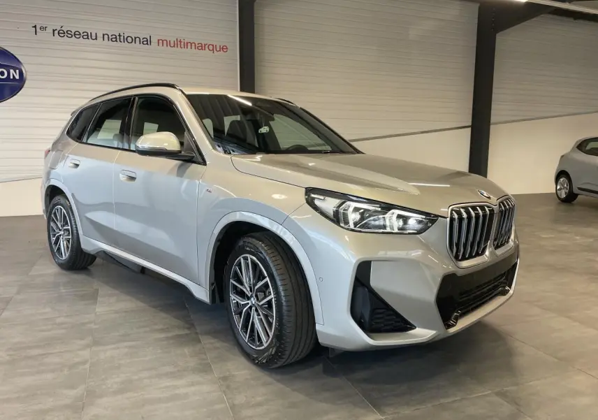 BMW X1 xDrive 20d 2024 en Spacesilber metallic, vue 3/4 avant droit avec calandre M Sport et jantes 18 pouces.
