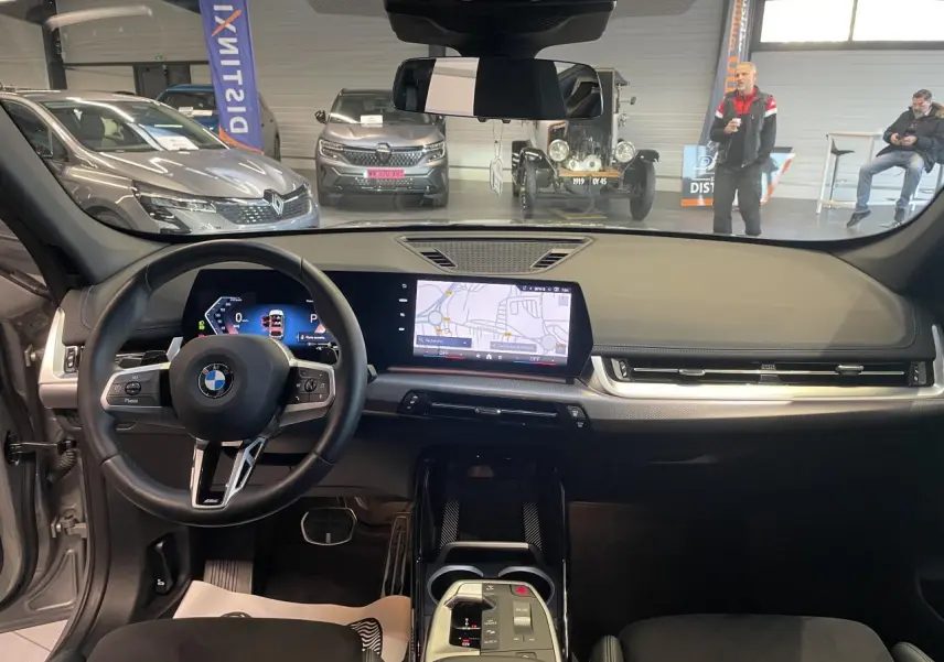 Vue intérieure avant du BMW X1 xDrive 20d 2024 en Spacesilber Metallic, tableau de bord numérique et volant M cuir.