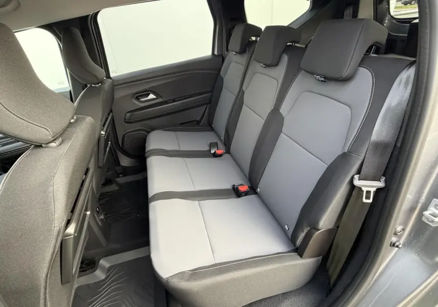 Vue intérieure côté droit sur la banquette arrière grise du Dacia Jogger 2025 avec sellerie mixte et ceinture de sécurité.